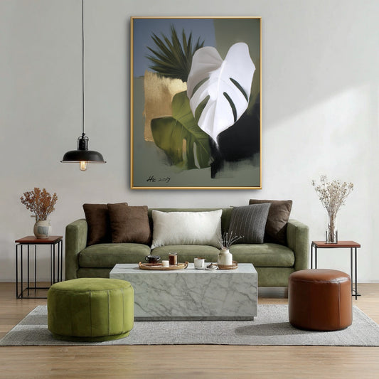 Modern living room with green sofa, marble table, and large abstract botanical wall art with gold and white leaves.