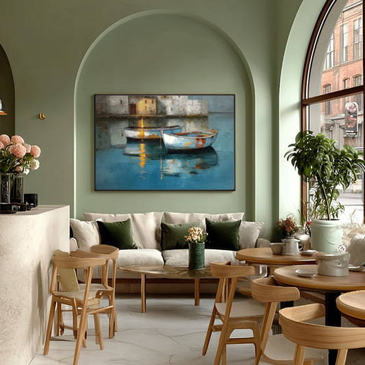 Boat painting adds deep cool color to a trendy cafe with sage green walls, wood chairs, and arched windows.