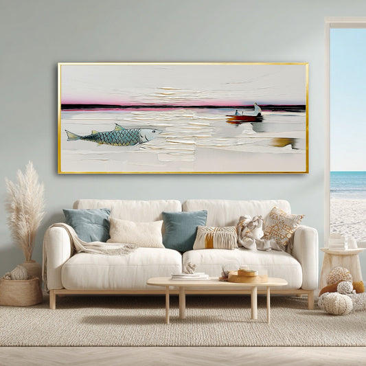 An original abstract seascape painting with a large fish and boat hangs above a beige sofa in a bright, coastal living room.