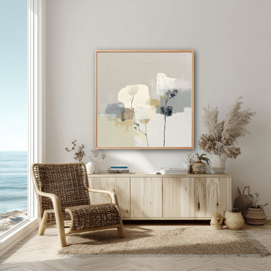A neutral abstract floral painting enhances a coastal boho living room, its organic tones matching the wicker chair and light wood console.
