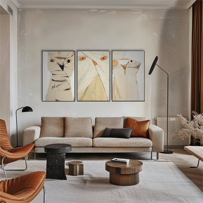 Beige owl fine art displayed above a cozy modern sofa with terracotta accents, flanked by two low floor lamps in a warm-toned room.
