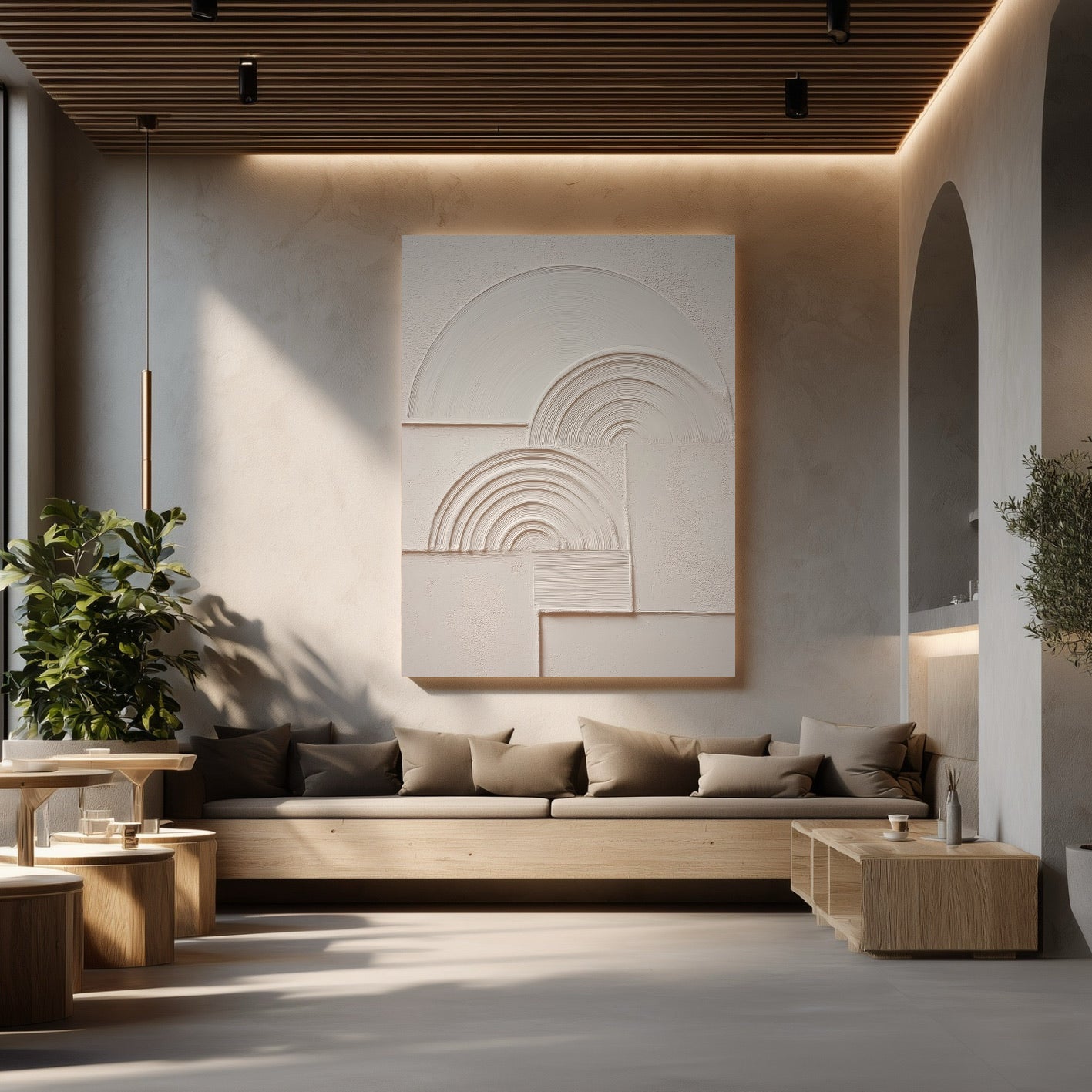 Large monochromatic plaster art in a serene, modern lounge with concrete floors and a long wooden bench sofa.