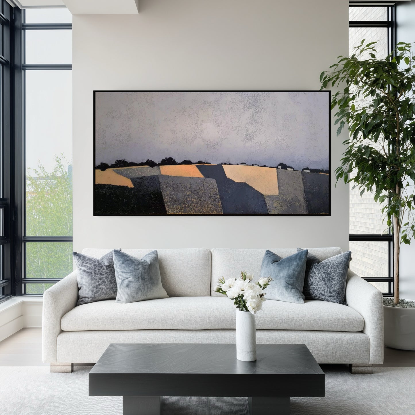 Original abstract fields painting above a modern white sofa. Bright living room with large windows, fostering a fresh, open aesthetic.