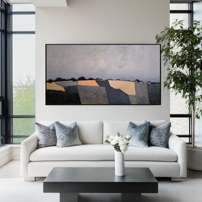 Original abstract fields painting above a modern white sofa. Bright living room with large windows, fostering a fresh, open aesthetic.