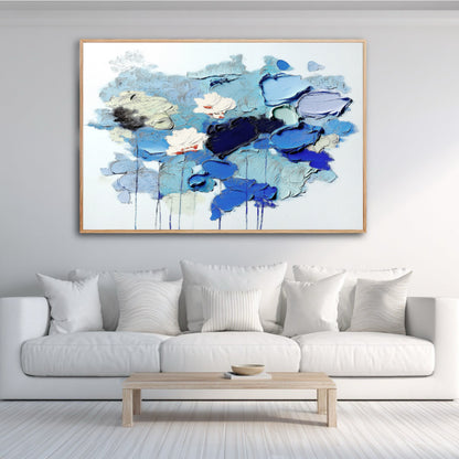 Contemporary blue textured artwork anchors a bright living room with seaside view. Coastal, minimalist decor.