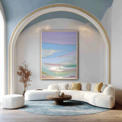 A vertical pastel abstract painting hangs under a large archway, complementing a modern white curved sofa and blue ceiling.