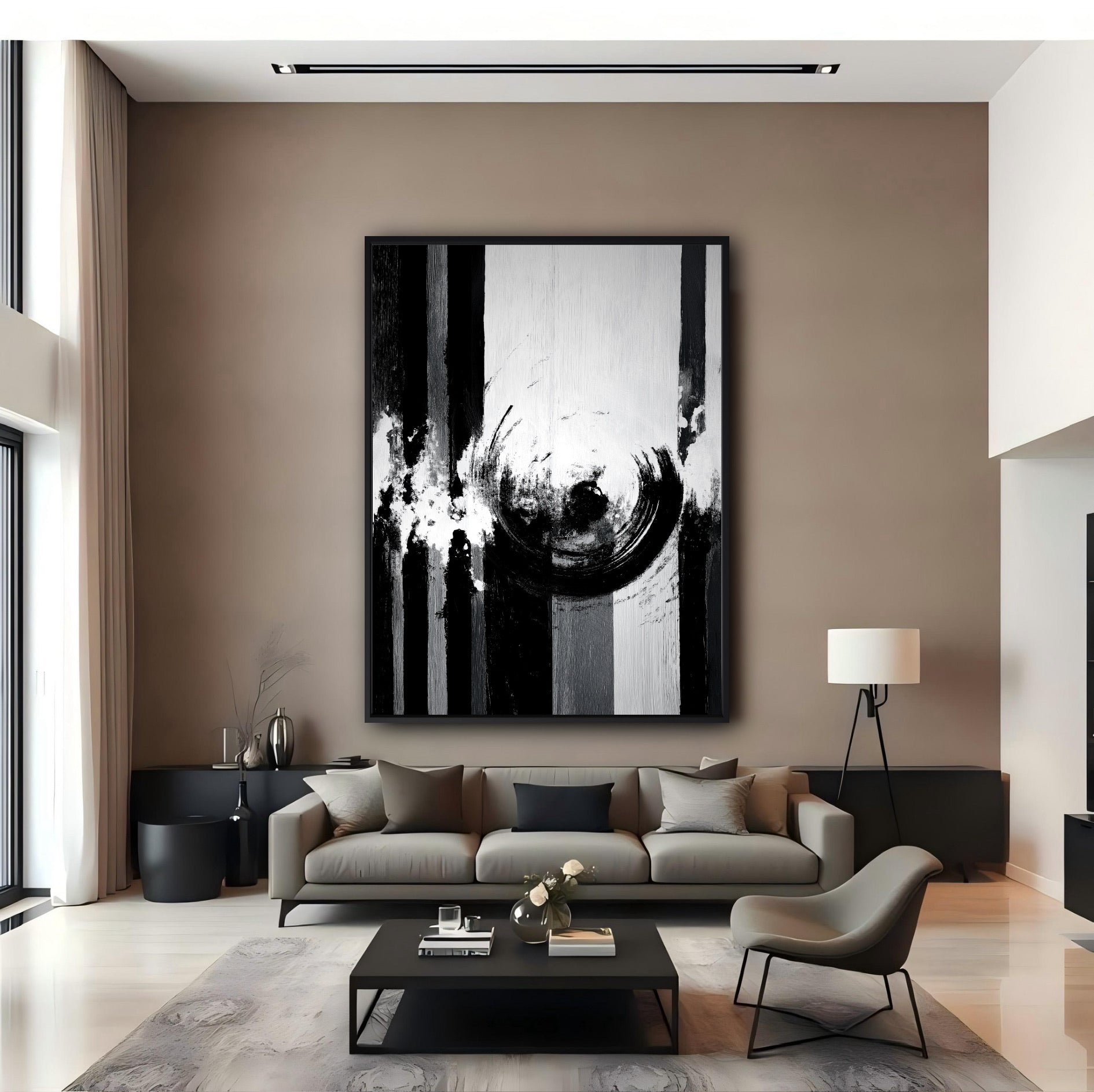 Tall vertical black and white abstract painting in a grand, minimalist living room with high ceilings and a neutral sofa.