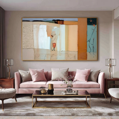 A large abstract painting hangs above a pink velvet sofa in a chic, modern living room with gold and glass accents.