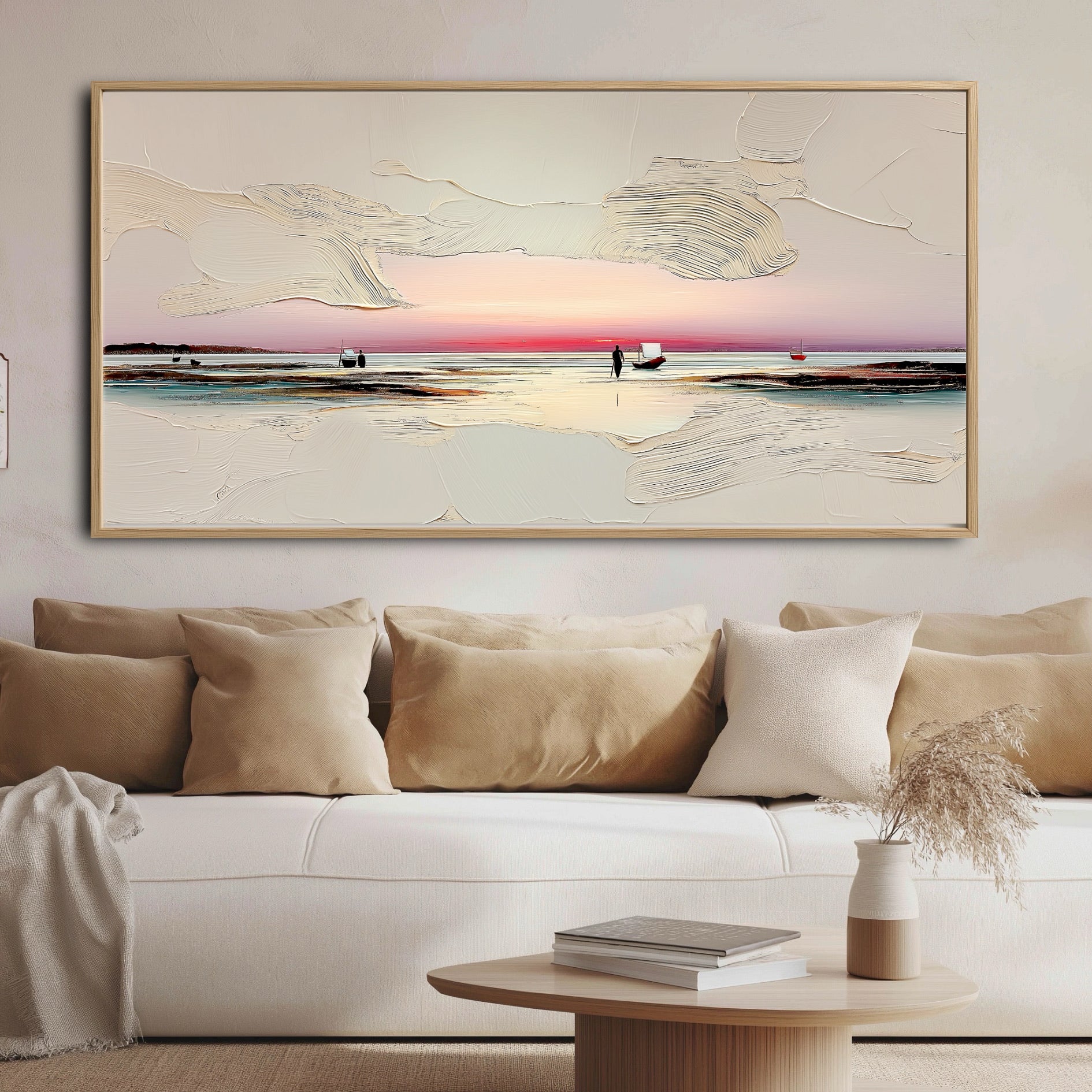 A horizontal seascape painting anchors a cozy living room, its warm pink tones and white texture matching the beige sofa and pillows.
