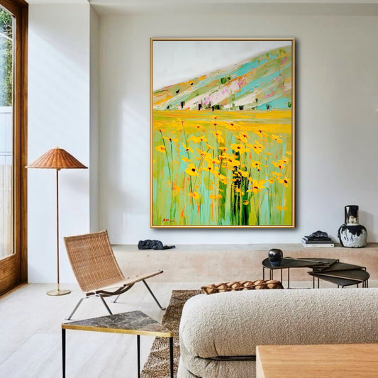 Original yellow flower field painting in bright living room. Landscape wall art adding warmth to modern wicker & wood decor.
