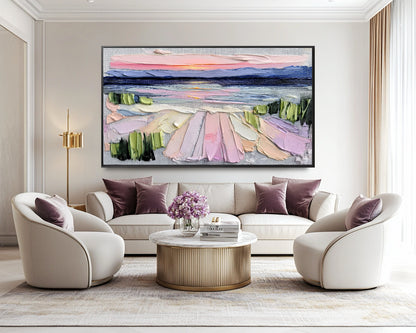 Original textured sunset art injects warm, vivid color above a large white sofa; perfect for a clean, bright living space with a welcoming vibe.