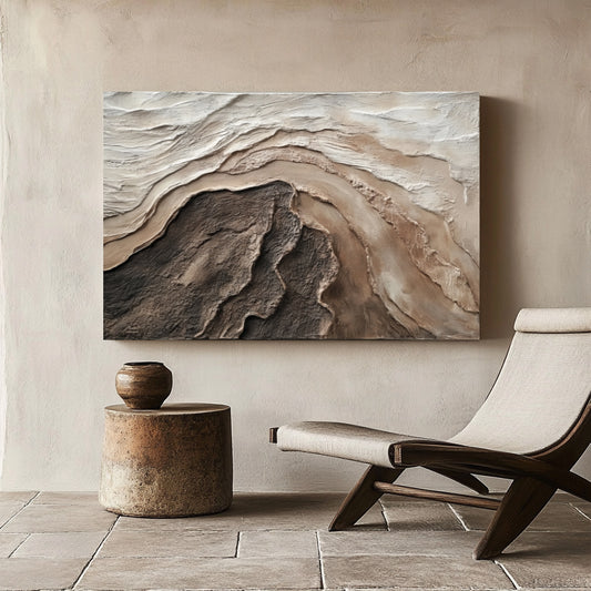 A large horizontal abstract painting with earth-tone textures creates a serene focal point above a modern chair and rustic table.