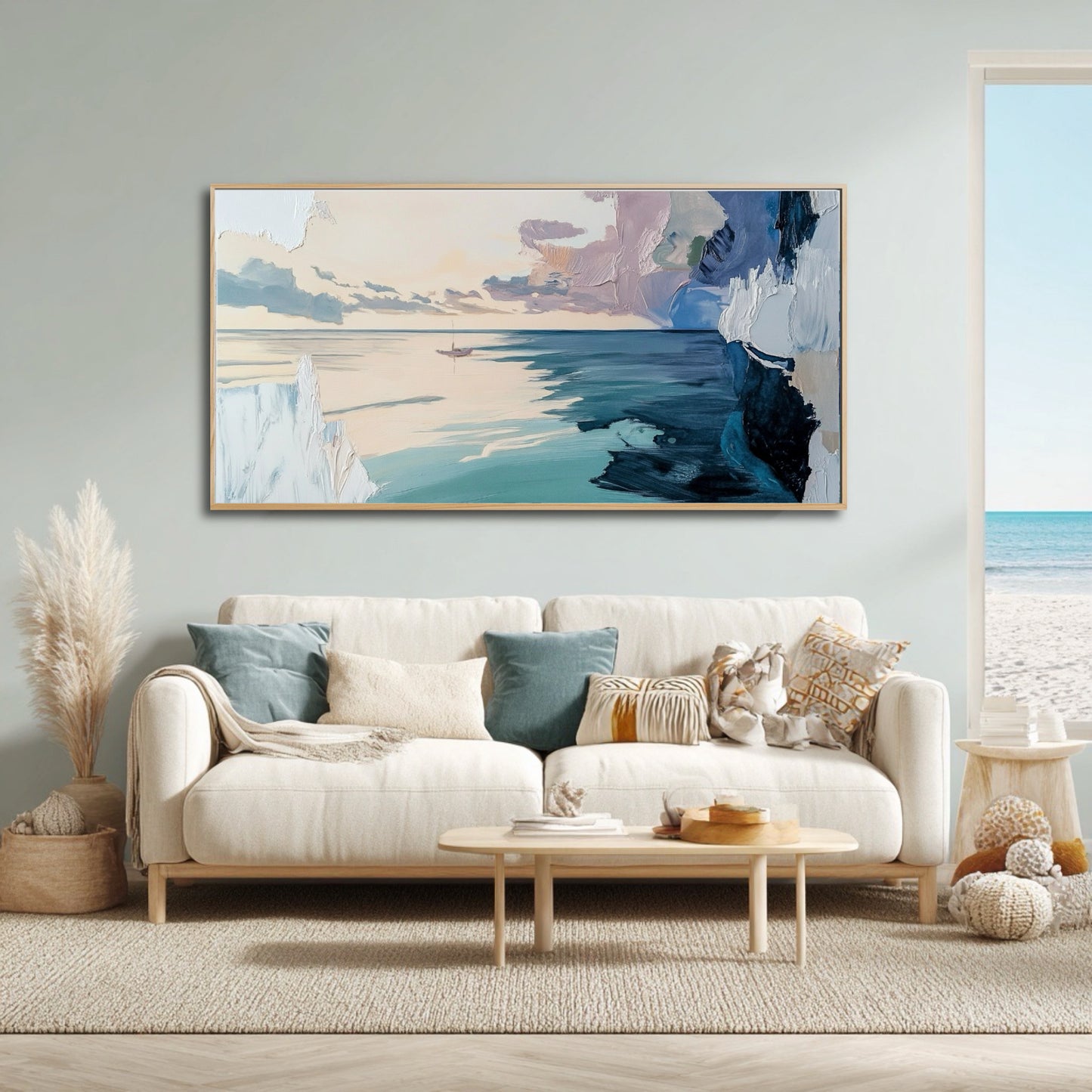 Airy coastal living room with a white sofa and beach view, featuring a large abstract ocean painting on a light blue wall.