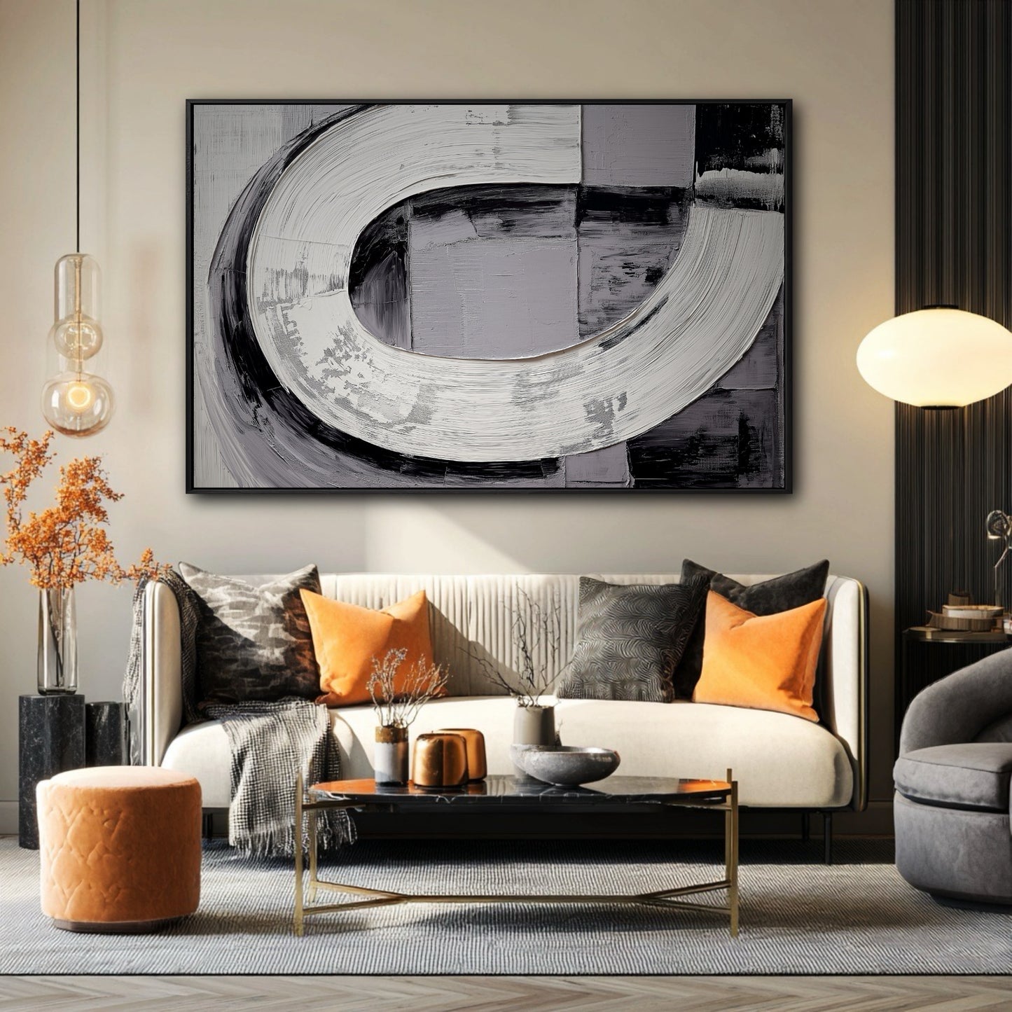 Large black and white abstract painting hanging above a sofa with bright orange pillows in a modern living room.