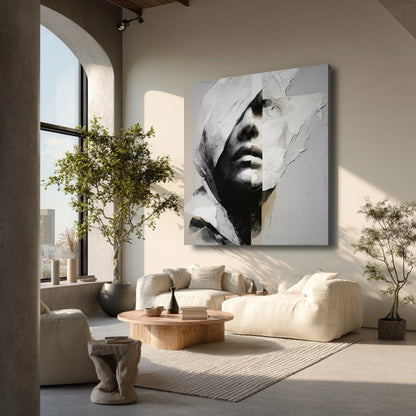 A square abstract painting hangs in a bright, airy minimalist living room with beige sofas, a tree, and a large arched window.