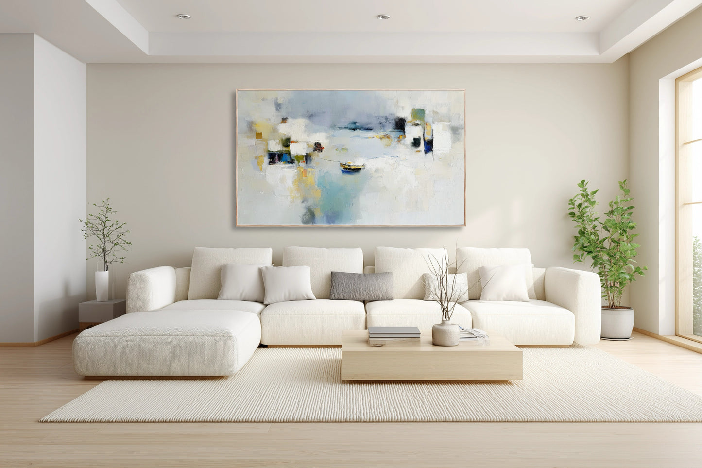 Abstract coastal art introducing soft blue and yellow color to a clean, airy, minimalist living room above a white sectional sofa.