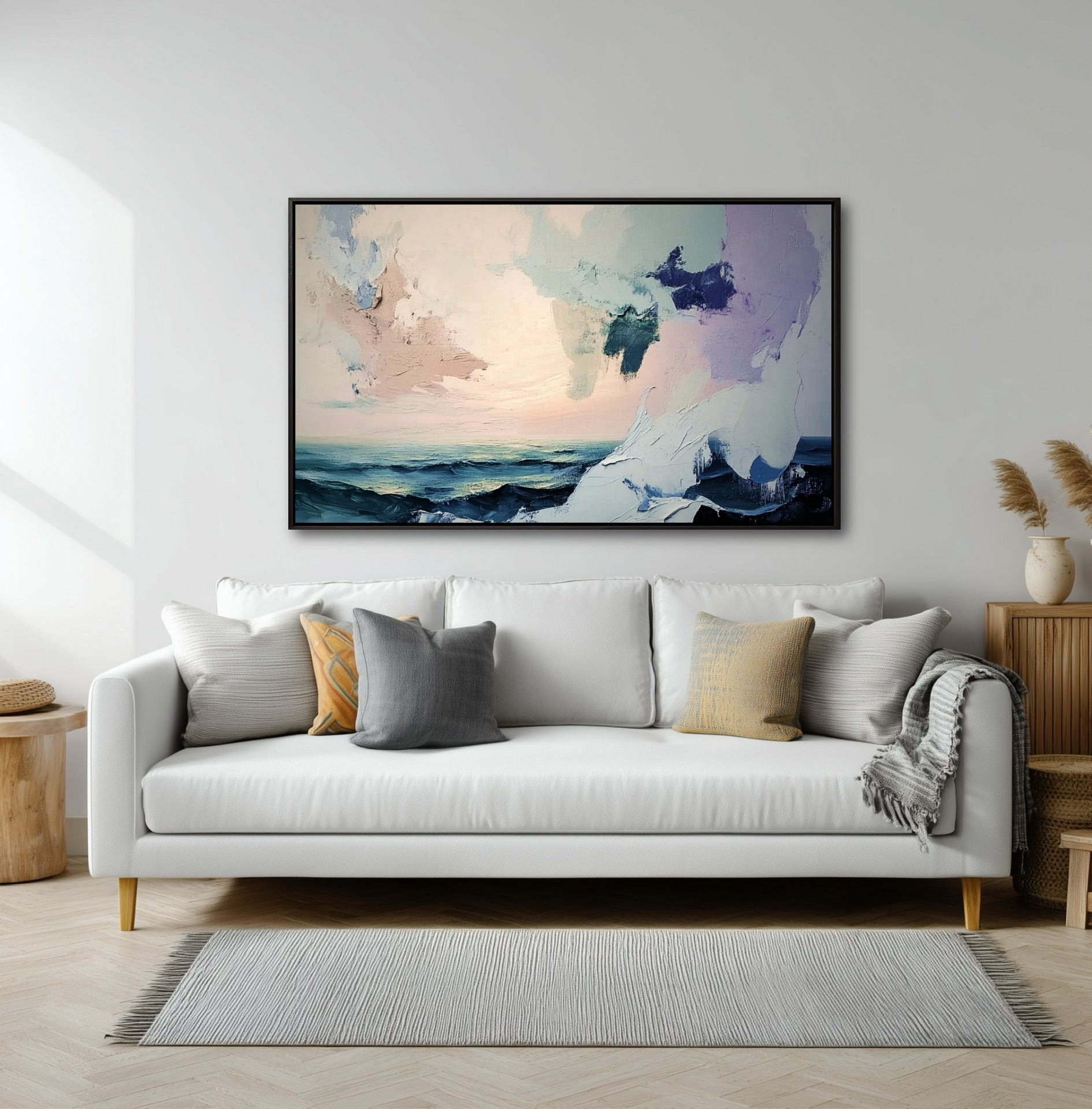 Modern living room with a white sofa and pampas grass, featuring a large abstract ocean painting on the main wall.