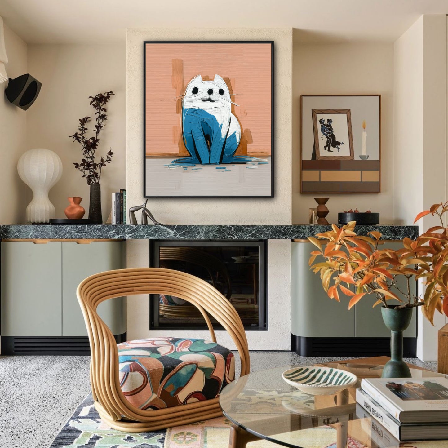 Modern blue cat painting displayed above a fireplace in an eclectic room with a mid-century rattan chair and green cabinets.