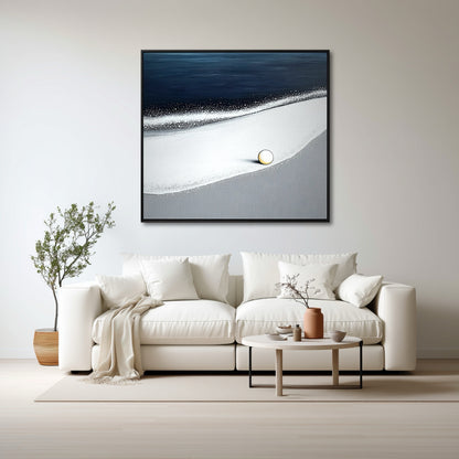 A minimalist ocean painting with a pop of gold hangs over a white sofa in a bright, Scandinavian-style living room.