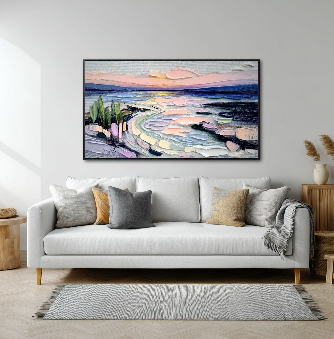 Original impasto landscape art adds vibrant warmth and color above a long, white minimalist sofa and natural wood side table in a sunny space.