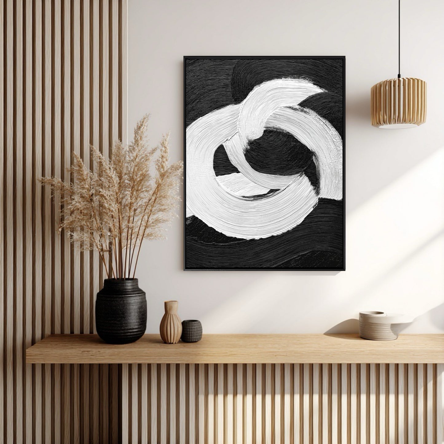 Vertical black and white impasto art on a wood slat accent wall above a console shelf with pampas grass.