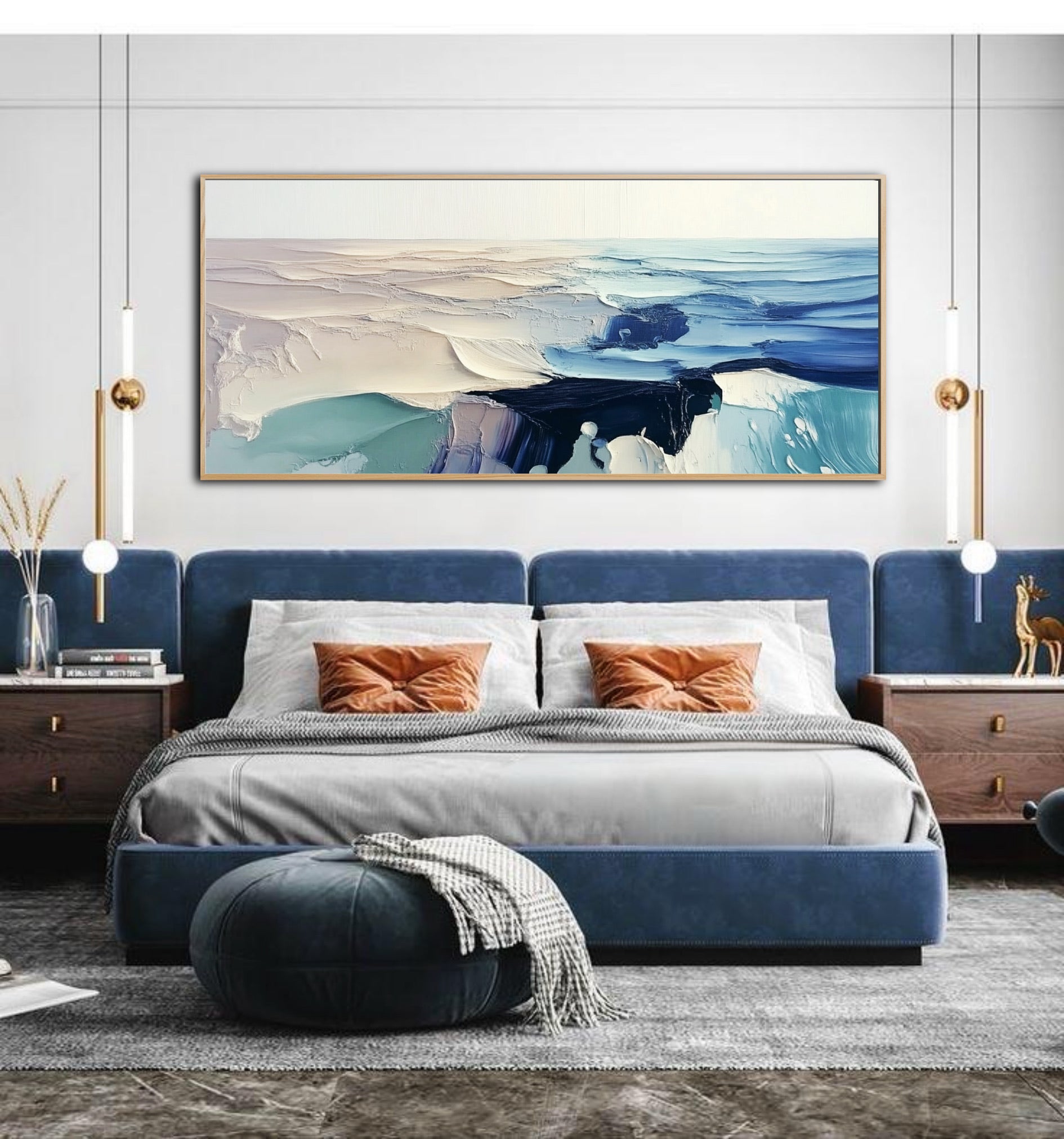 Modern bedroom featuring a blue velvet bed and gold pendant lights, with a large, textured abstract seascape hanging above.