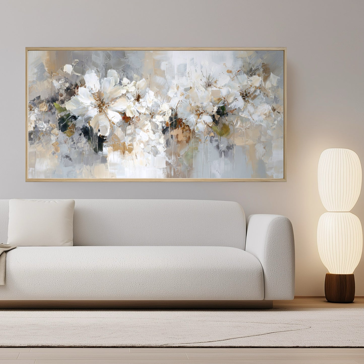 A panoramic abstract floral painting hangs above a white sofa in a minimalist living room, its neutral tones matching the serene decor.