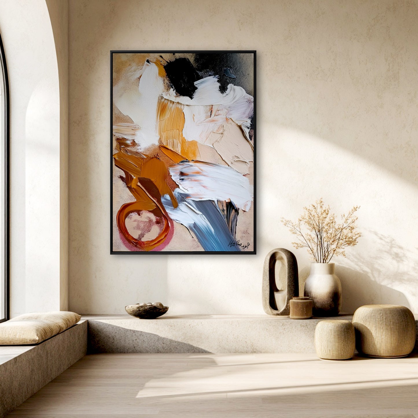 Original textured abstract painting in a minimalist, beige room with a built-in stone bench and an arched window.