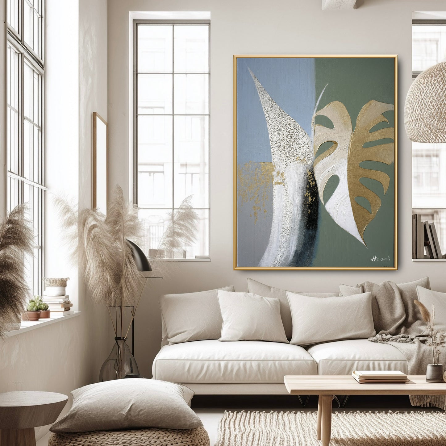 Large statement art piece in bright minimalist living room. Abstract gold & sage painting anchors white sofa and airy window space.