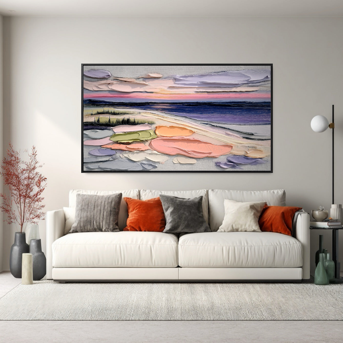 Original textured landscape art provides a burst of warm color above a white sofa; accented by orange and gray pillows for a high-contrast, bold look.