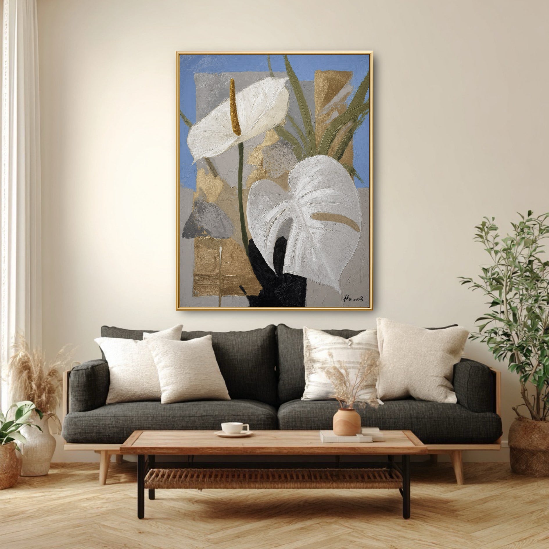 Blue and gold floral wall art styled over dark grey couch. Large vertical painting adding softness to modern masculine decor.