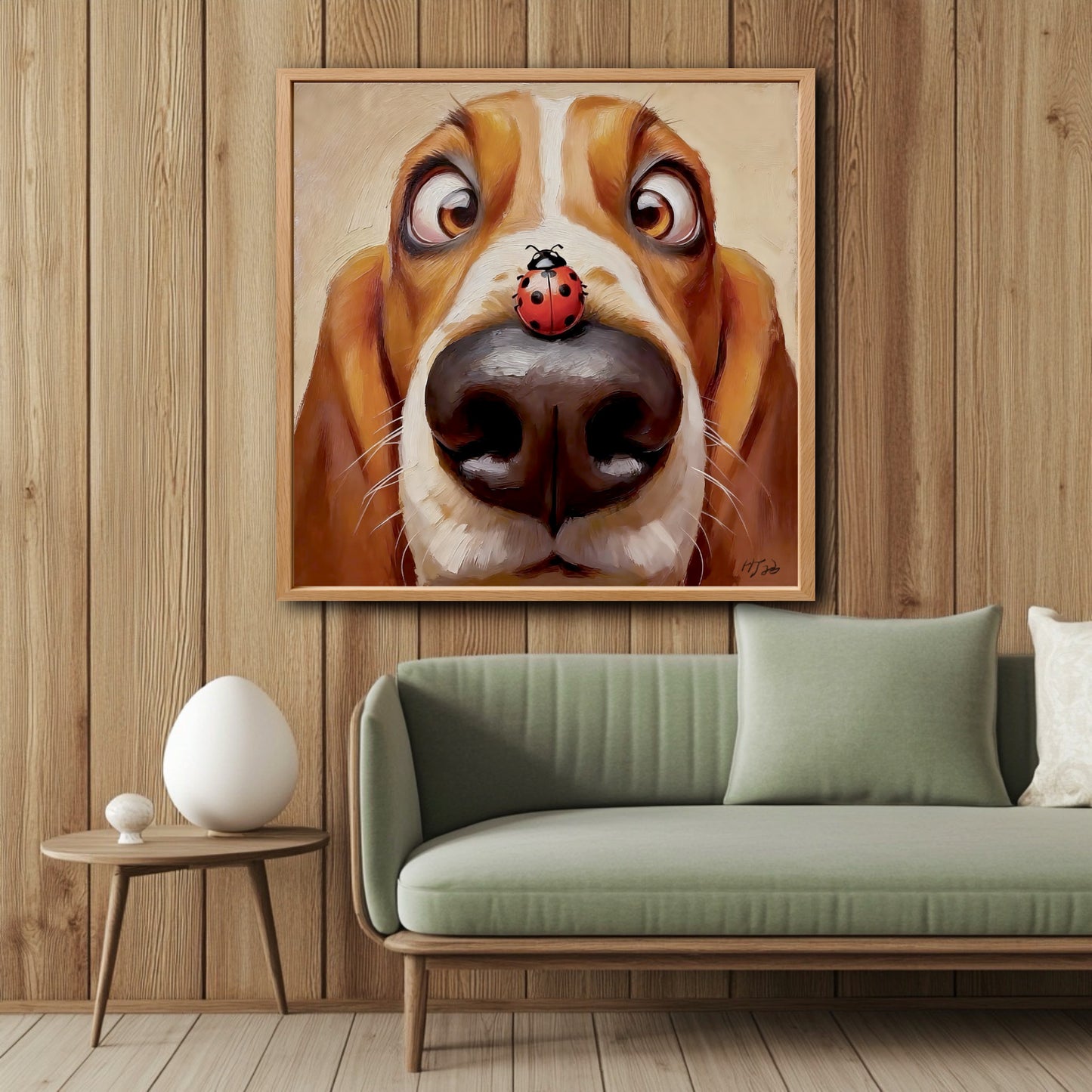 Funny Basset Hound painting hanging on a vertical wood-paneled wall above a modern sage green sofa in a cozy living room.