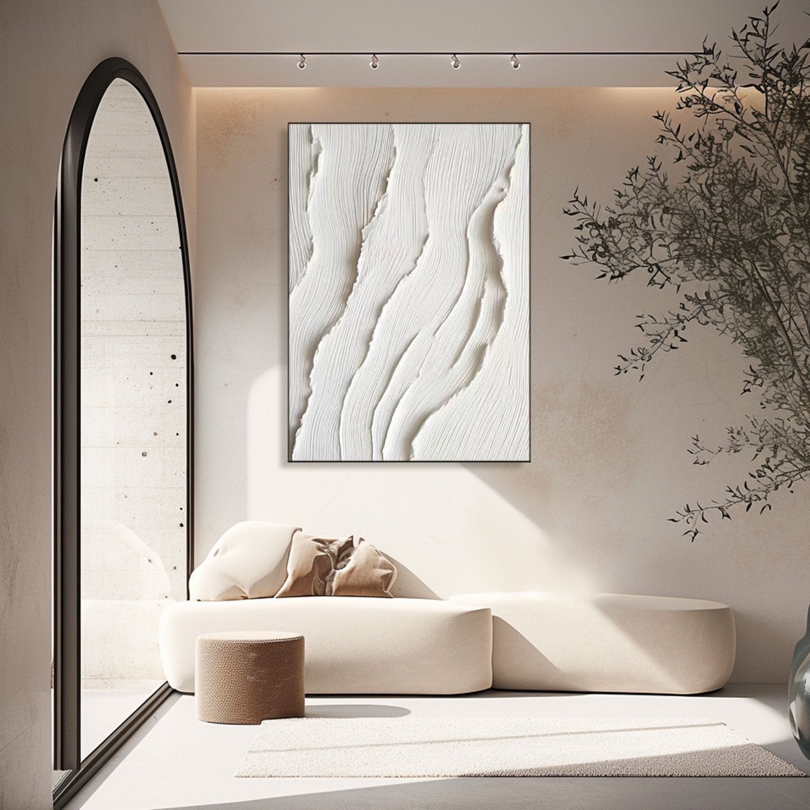 White abstract art in an intimate nook, framed by a large arch mirror and lit by spotlights to highlight the deep texture.
