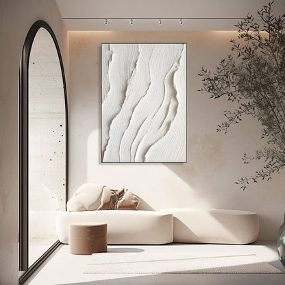 White abstract art in an intimate nook, framed by a large arch mirror and lit by spotlights to highlight the deep texture.