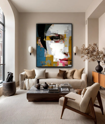 A large, abstract face painting hangs as a colorful focal point in a spacious, elegant living room with a neutral sofa and high ceiling.