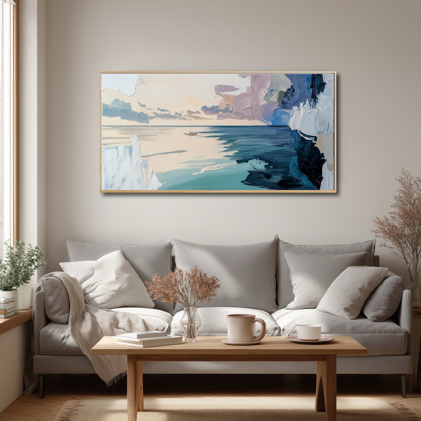 Cozy, neutral-toned living room with a grey sofa and wood table, featuring a large abstract seascape by a bright window.