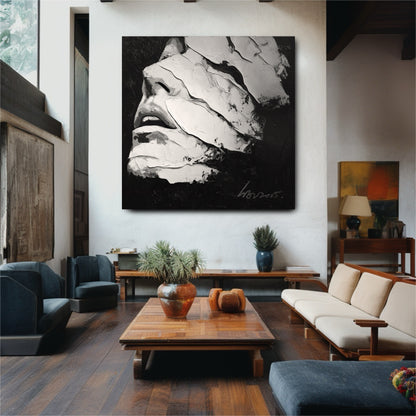 A square abstract face painting in monochrome hangs as a focal point in a spacious room with warm wood floors and furniture.