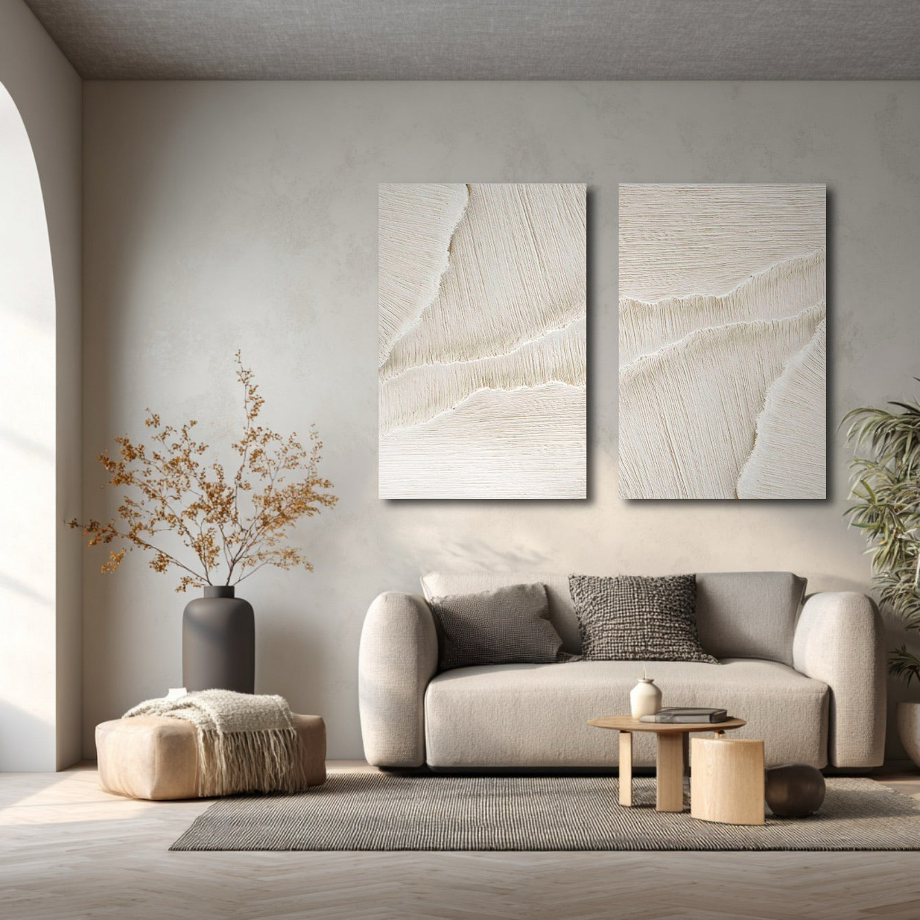 Textured neutral art enhancing a muted, minimalist living area with soft light and a graceful arched doorway.