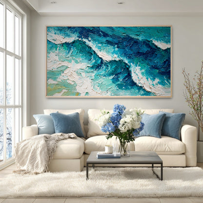 The vibrant blue wave painting adds energy to a modern room, its colors matching the blue pillows on the white sectional.