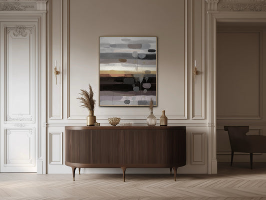 Elegant abstract artwork enhances the classic wainscoting and sophisticated mid-century modern dark wood console table.
