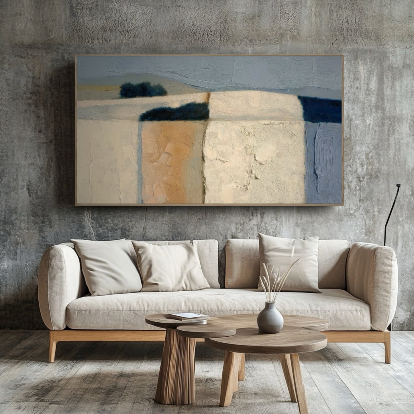 Original abstract landscape pops against a rough concrete accent wall. The simple sofa and wood tables enhance the contemporary-industrial design.