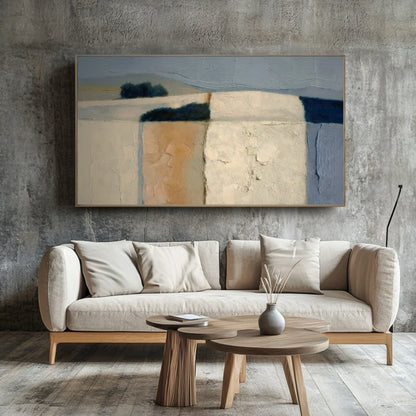 Original abstract landscape pops against a rough concrete accent wall. The simple sofa and wood tables enhance the contemporary-industrial design.