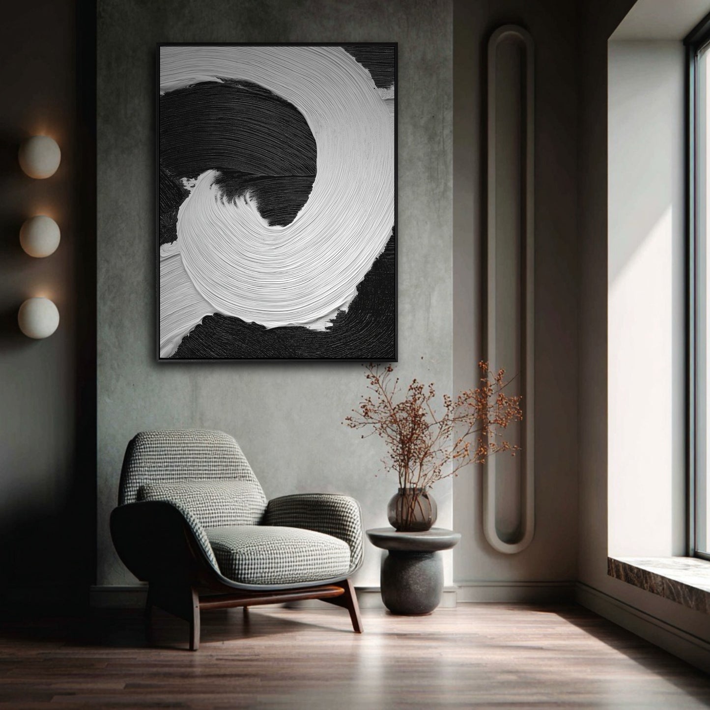 Large black and white abstract art with heavy texture in a moody, minimalist room with a grey armchair and modern wall sconces.