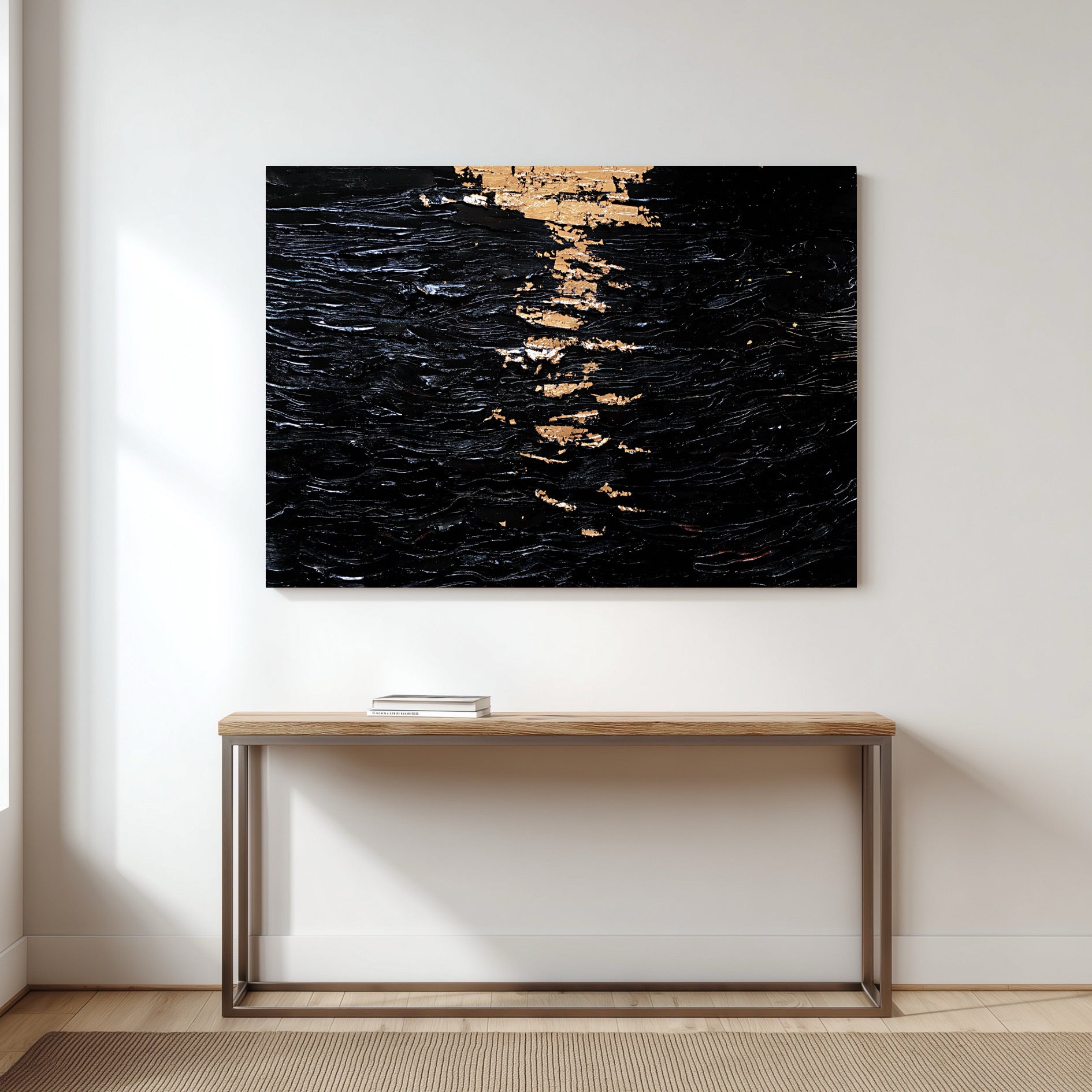 A large black and gold abstract painting hangs on a white wall in a minimalist hallway, centered above a simple wood console table.