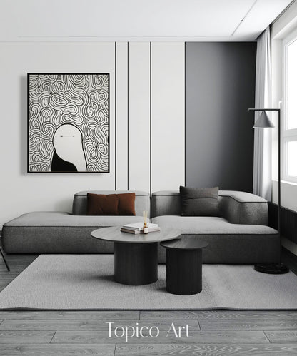Abstract feline painting above a gray sectional in a minimalist lounge, adding dynamic pattern and stark contrast to the neutral space.