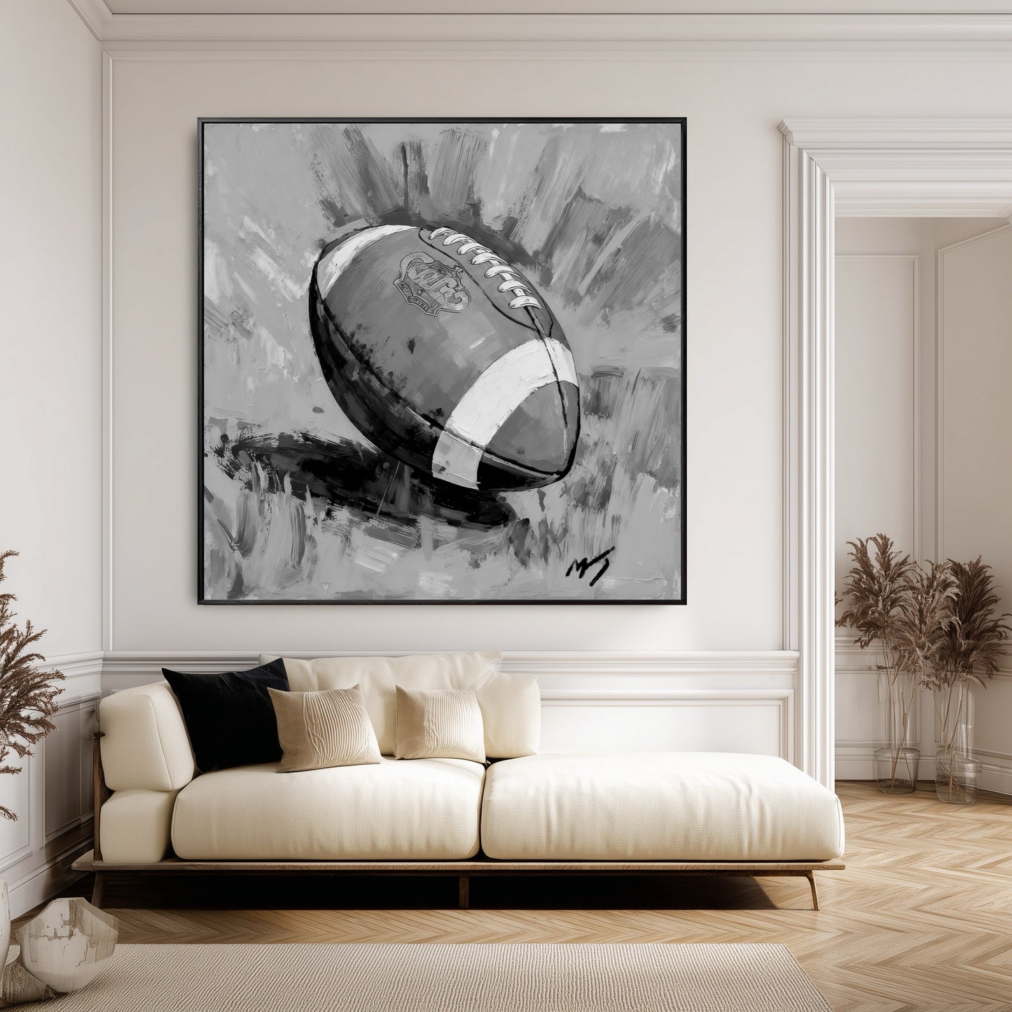 Large painting of a football in a modern classic room with white wall paneling and a low-profile cream-colored sofa.