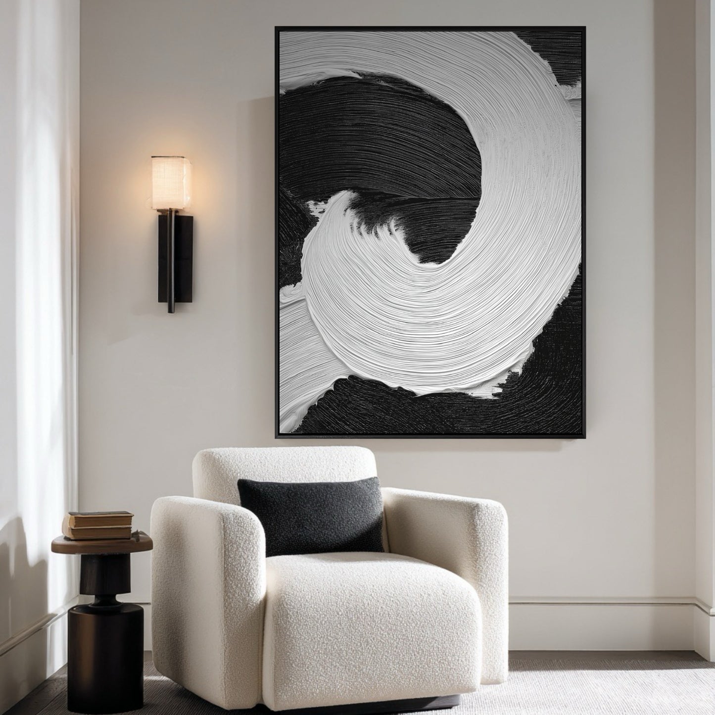 Vertical black and white abstract painting adds contrast to a bright, minimalist room with a white boucle armchair and black pillow.