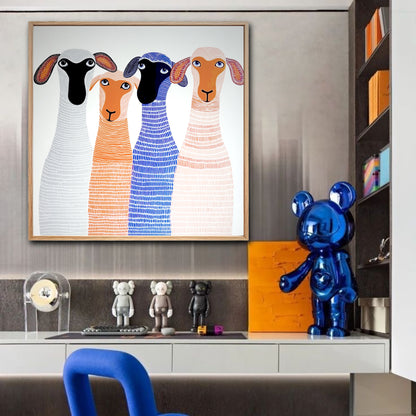 Modern sheep art in a wood frame displayed in a stylish office above a desk with designer toys and a blue sculptural chair.