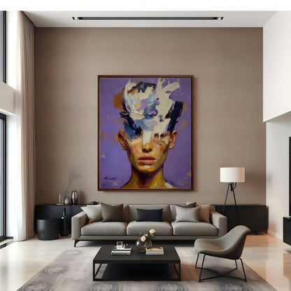Large framed abstract portrait hanging in a modern living room with high ceilings, a gray sofa, and minimalist decor.