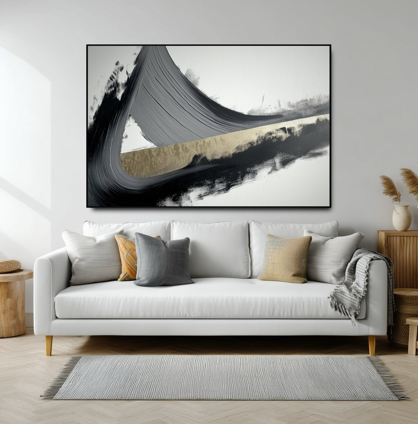 Large horizontal abstract with a powerful black and gold brushstroke over a modern white sofa in a bright living room.